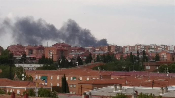 Imagen de la columna de humo generado en un incendio de una planta de reciclado de papel, en el distrito madrileño de Vicálvaro.