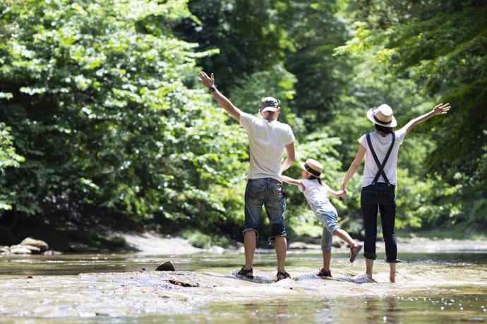 Familia de vacaciones feliz de excursión en un río.
