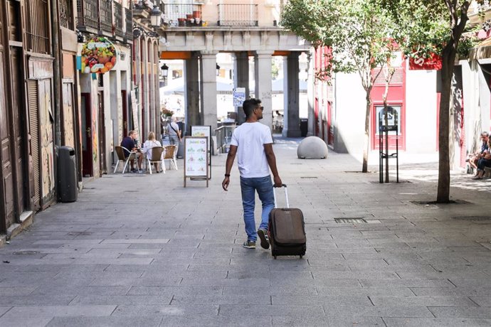 Imagen de recurso de un turista que pasea con una maleta por el centro de Madrid.