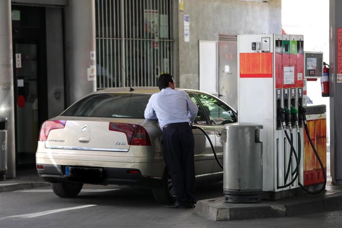 Personas ponen gasolina en sus coches en una gasolinera de Madrid.