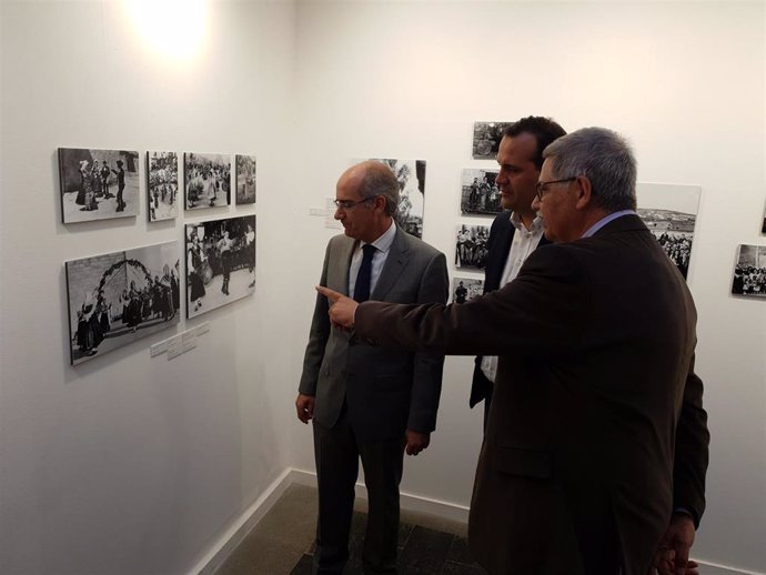 Javier Iglesias (i), Franciso Blanco (d) y David Mingo (c) observan fotografíass de la exposición en La Salina.