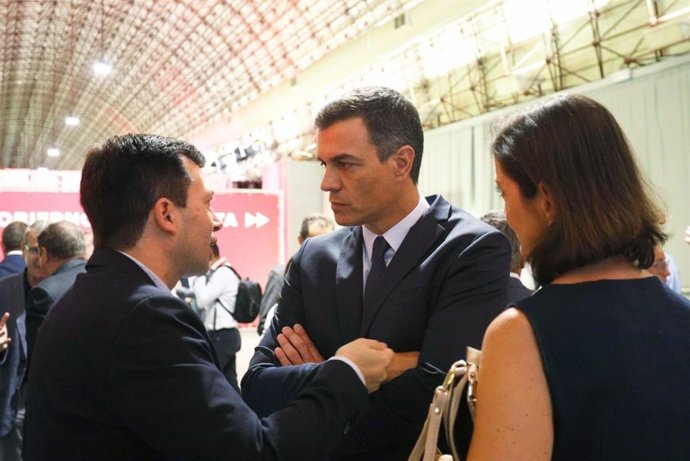 El secretario general del PSdeG, Gonzalo Caballero, habla con el presidente del Gobierno en funciones, Pedro Sánchez, en el acto de presentación de medidas del PSOE en Madrid