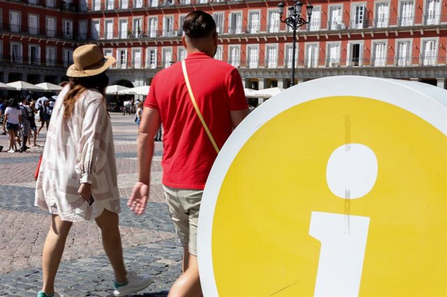 Varios turistas entran en la oficina de turismo de la Comunidad de Madrid ubicada en la Plaza Mayor de Madrid.