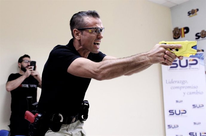 Un agente del Sindicato Unificado de Policía (SUP) realiza una demostración del funcionamiento de la pistola eléctrica durante la presentación del proyecto para incorporarla en la Policía Nacional