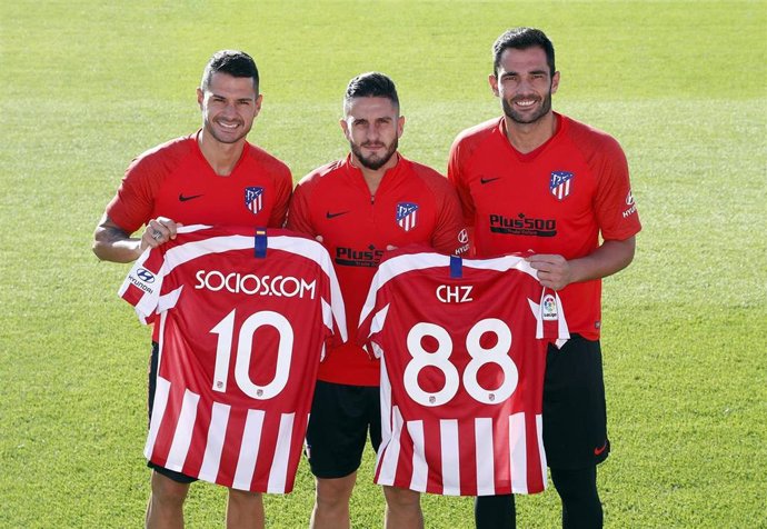 Los jugadores del Atlético Vitolo, Koke y Adán con la camiseta de Socios.Com