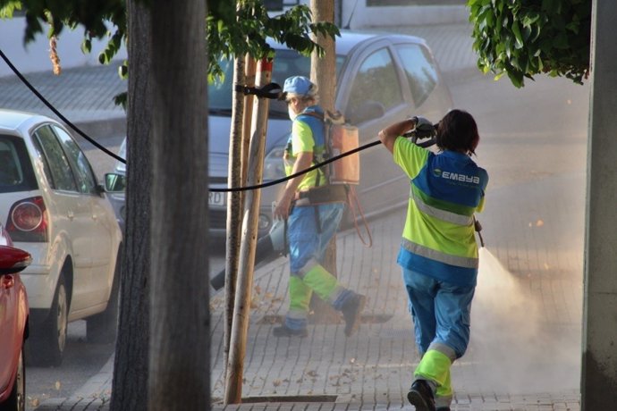 Operarios de Emaya limpian en una calle con mangueras.