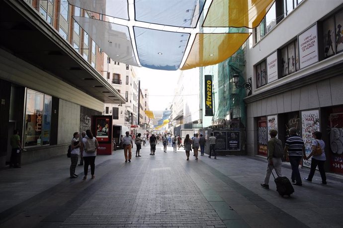 Turistas y vecinos de la zona Centro de Madrid pasean por la calle Preciados bajo la sombra gracias a los toldos instalados