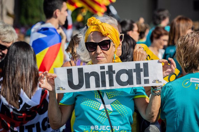 Un dona subjecta un cartell en el qual es llegeix 'Unitat' (Unitat)  durant la manifestació convocada per l'Assemblea Nacional Catalana (ANC) amb el lema 'Objectiu Independncia (Objectiu independncia)', dins dels actes de la Diada de Catalunya 2019, e