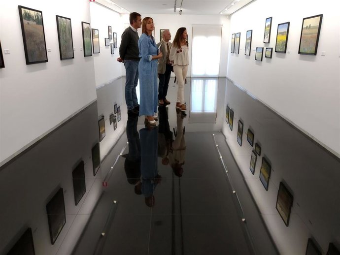La diputada de Promoción Agroalimentaria, Inmaculada Toledano, visita la exposición 'Campo de luz' junto al artista Pablo Giménez.