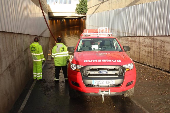 Bomberos a la entrada del tunel anegado por el temporal donde ha muerto una persona.