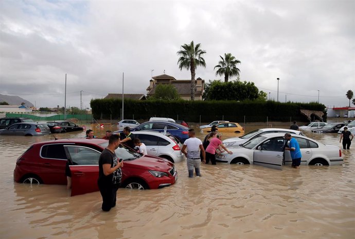 Afectats pel temporal amb els seus cotxes parcialment submergits a Oriola (Alacant).