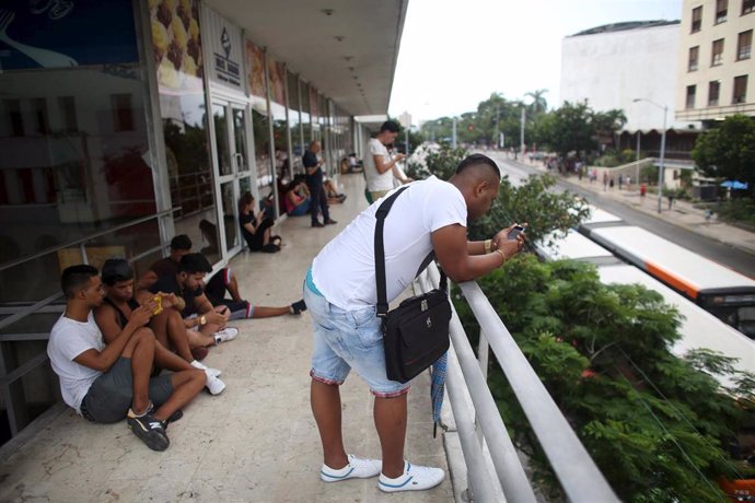 Cubanos en un puesto público de conexión WiFi