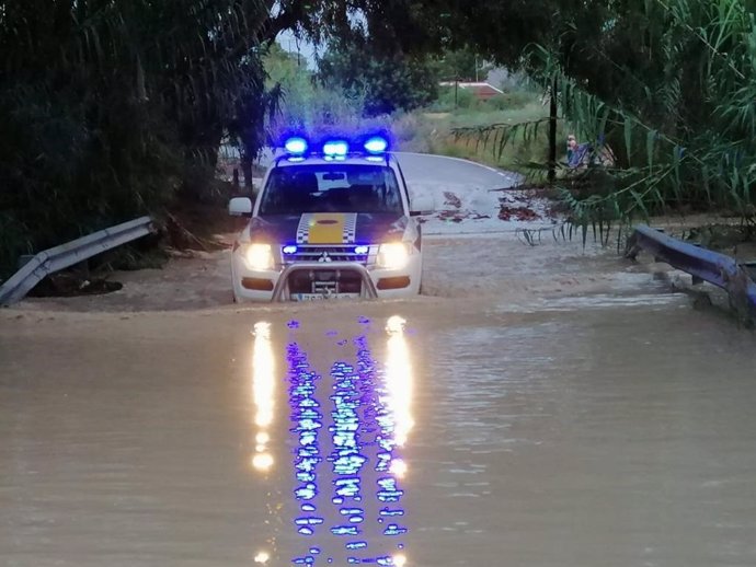 Coche de la Policía Local de Alicante en un camino anegado por la lluvia