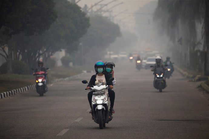 Motoristas atraviesan la niebla provocada por el humo de los incendios en Indonesia.
