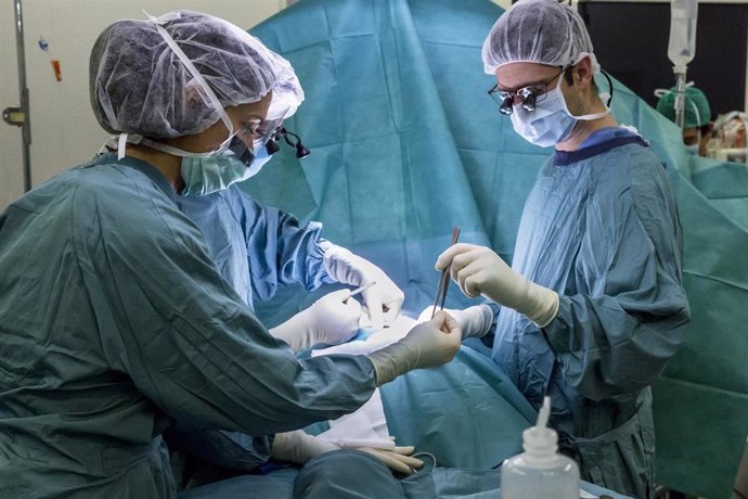 Enfermera instrumentista asiste a un cirujano en un quirófano