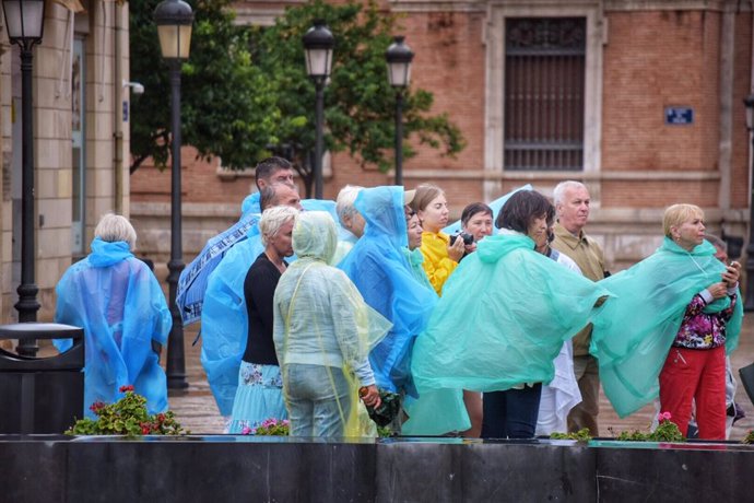Un grupo de turistas siguen una visita guiada por el centro de Valencia con chubasqueros para protegerse de la lluvia, durante el temporal de gota fría que afecta a la zona de Levante, en Valencia (España) a 11 de septiembre de 2019.