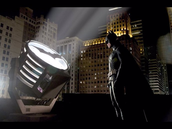 Batman frente a la Batseñal en los tejados de Gotham