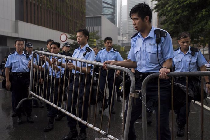Policías en Hong Kong poniendo vallas para  detener a los manifestantes