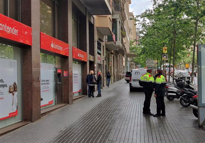 Agentes de Mossos d'Esquadra ante el edificio de la calle Comte Urgell de Barcelona donde se produjo el homicidio en mayo.