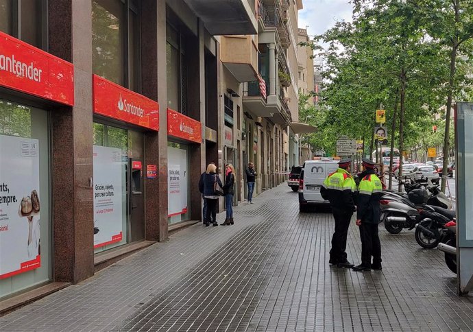 Agents de Mossos d'Esquadra davant l'edifici del carrer Comte Urgell de Barcelona on es va produir l'homicidi al maig.