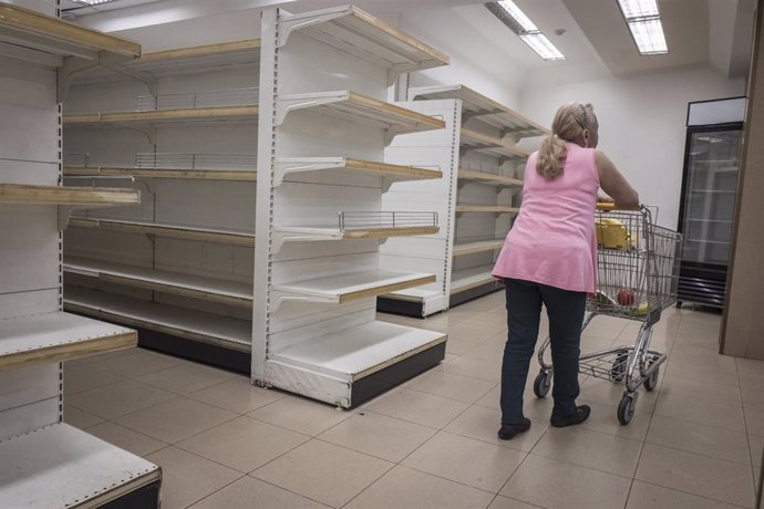 Una mujer en un supermercado prácticamente vacío en Caracas
