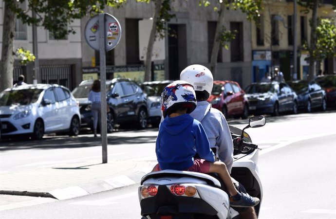 Un hombre y su hijo montados en moto en Madrid.