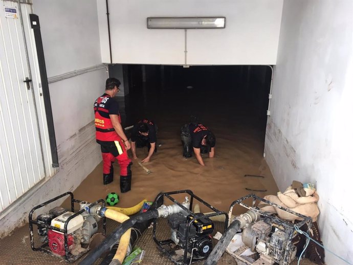 Voluntarios de Protección Civil y bomberos del CEIS trabajan en el achique de agua en un sótano de Los Alcázares
