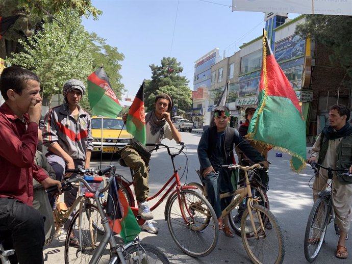 Chicos afganos con la bandera del país