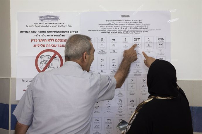 Dos personas se preparan para votar en las parlamentarias en Israel