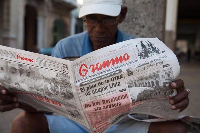 Un hombre lee el diario Granma en Cuba. 