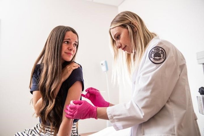 Enfermera poniendo una vacuna.