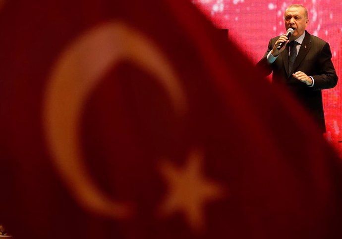 Recep Tayyip Erdogan junto a la bandera de Turquía