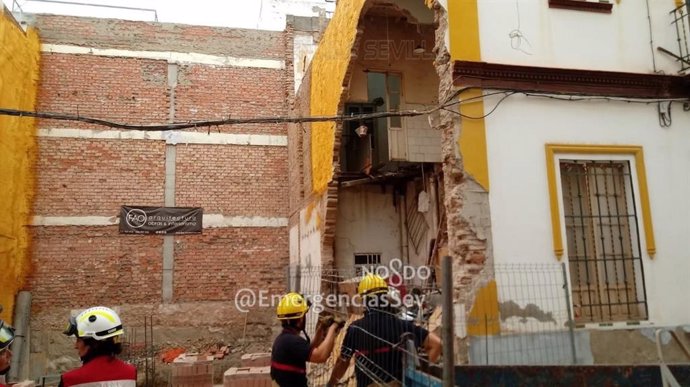 Intervención de los bomberos en el derrumbe de una medianera en una vivienda de la calle Garci Fernández de Sevilla