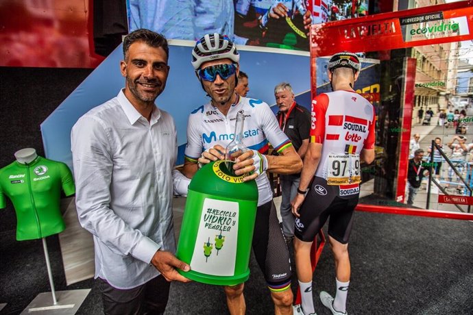 Oscar Pereiro (izquierda) sujeta el contenedor de Ecovidrio mientras que Alejandro Valverde (derecha) deposita una botella