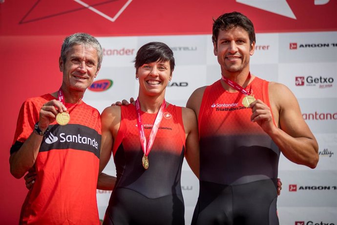 Martín Fiz (izda), Eider Fuentes y Eneko van Horenbeke celebran su victoria en el Santander Getxo Triatlón