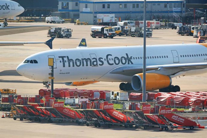 23 September 2019, England, Manchester: An Airbus A330 from the airline Condor with the design of the tourism company Thomas Cook stands on the tarmac at  Manchester Airport. Thomas Cook, one of Britain's biggest travel firms, filed for liquidation earl