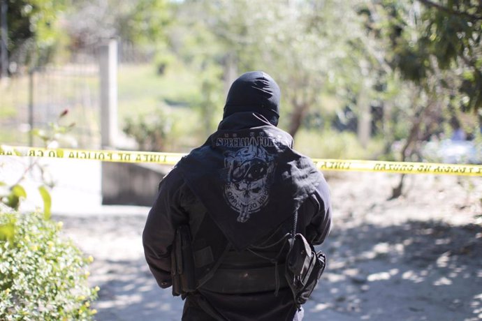 Un policía vigila la escena de un crimen en El Salvador