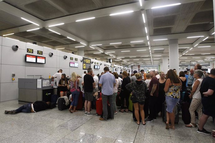Varios turistas hacen cola frente a los mostradores de la compañía Thomas Cook en el aeropuerto de Palma de Mallorca (Baleares), horas después de que la compañía británica anunciase su quiebra, a 23 de septiembre de 2019.