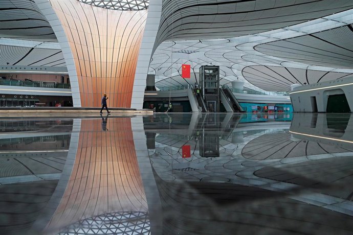 Un trabajador pasea por una terminal en el aeropuerto de Internacional de Daxing, en Pekín