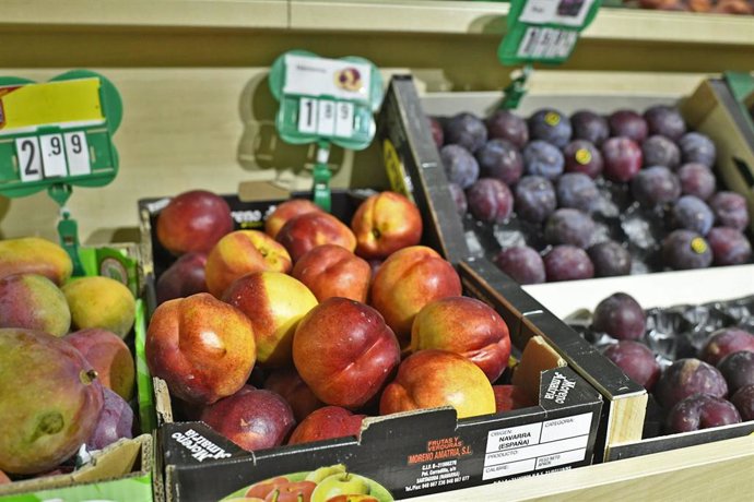 Fruta variada: caja de manzanas, caja de ciruelas y caja de mangos.