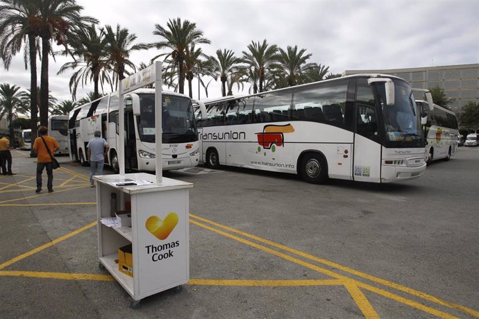 Puesto de información vacío de la compañía de viajes Thomas Cook en el aeropuerto de  Palma de Mallorca (Baleares) frente a varios autocares, horas después de que la empresa británica anunciase su quiebra y de que varios de sus vuelos fuesen cancelados,