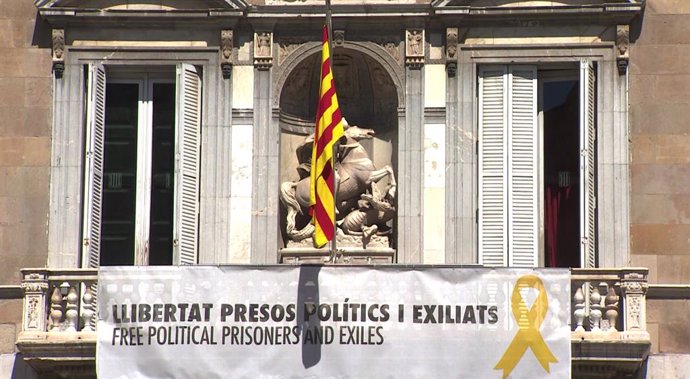 El palau de la Generalitat torna a penjar una pancarta en la qual es llegeix 'Llibertat presos polítics i exciliats', juntament amb un lla groc, un dia després de les eleccions autonmiques, municipals i europees.