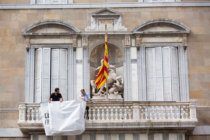 Retiren la pancarta con el lla groc de la faana de la Generalitat.