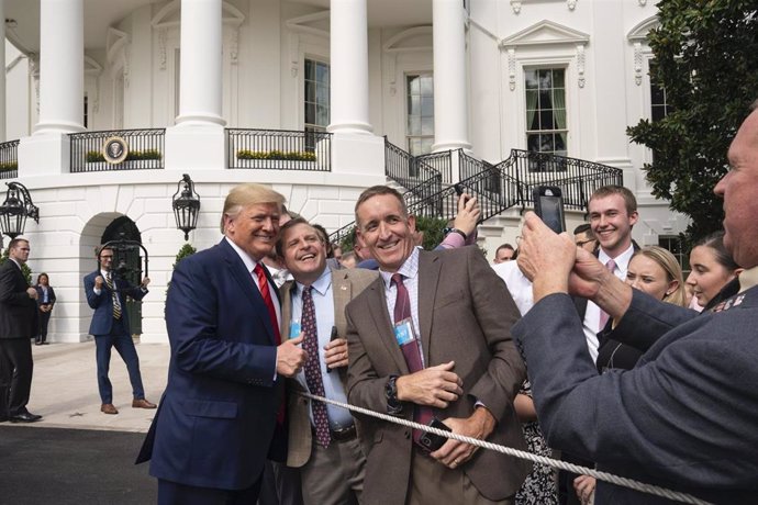 Donald Trump posa con seguidores ante la Casa Blanca