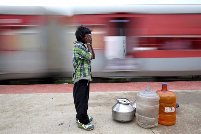 Niño esperando al tren para poder ir a buscar agua