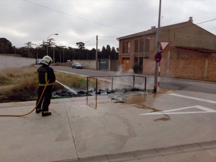 Un bombero sofoca el incendio de cuatro contenedores en Cortes