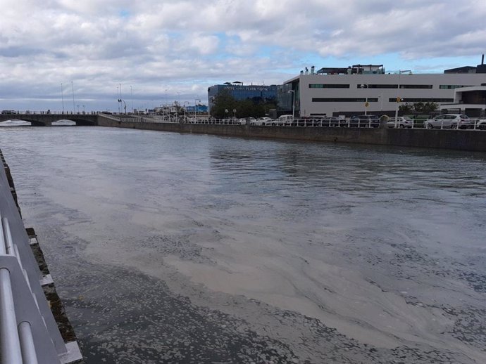 El río Piles, en Gijón, lleno de espuma cerca de la desembocadura en la Playa de San Lorenzo.