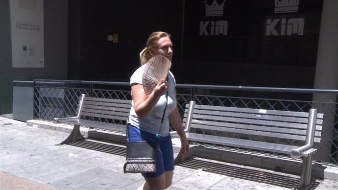 Una mujer se abanica mientras pasea por Mérida (Badajoz)