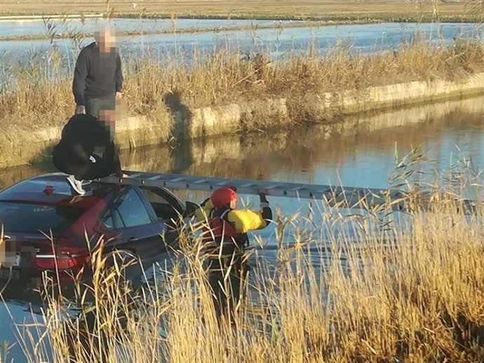 Rescatan a dos personas del techo de un coche caído a una acequia de El Perelló en febrero de 2019
