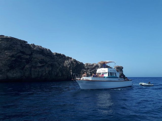 Una pequeña embarcación en las idílicas aguas de la isla de Menorca